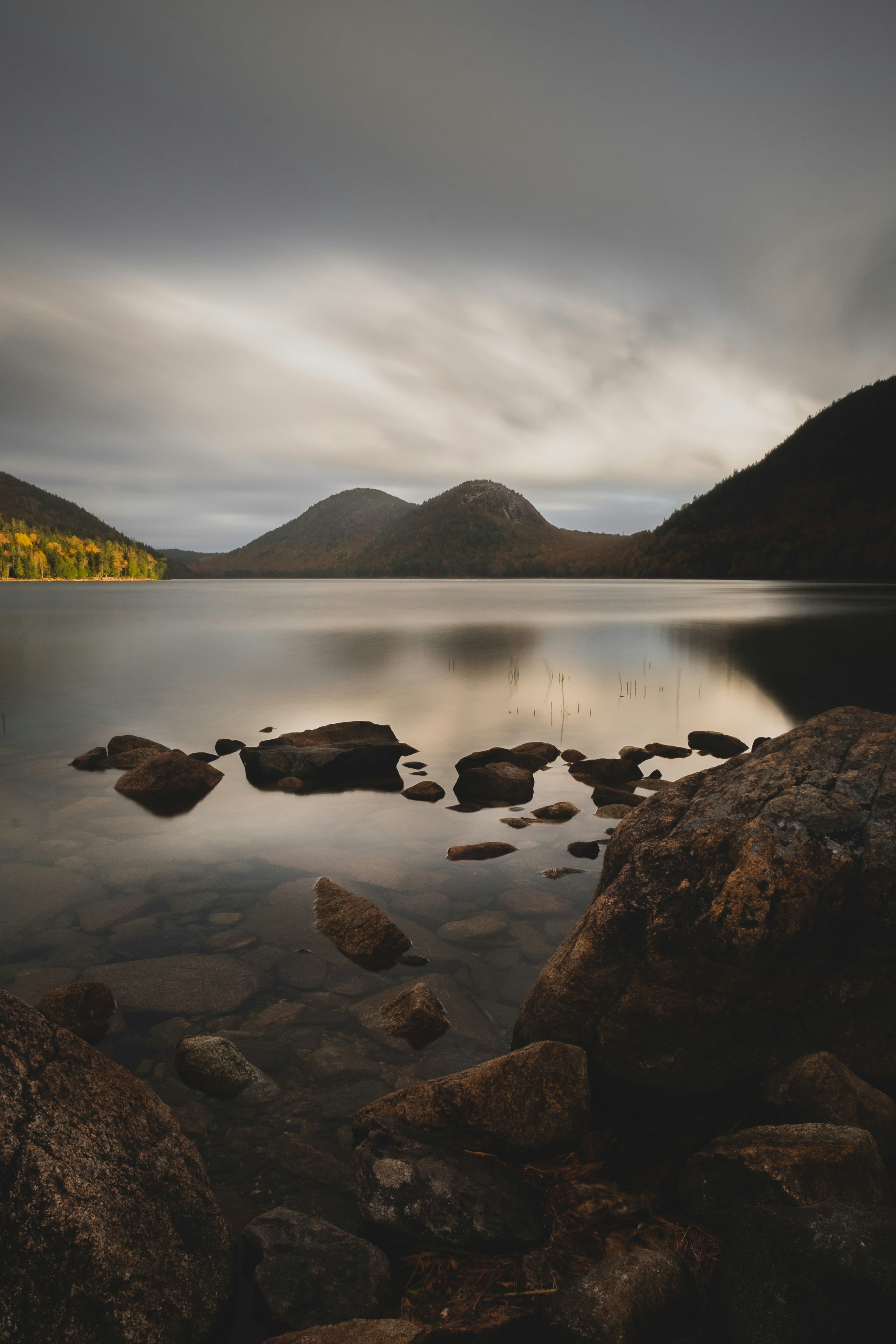 black rocks on body of water during daytime